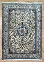 "Elevate your home decor with our exquisite Nain Handmade Rug, meticulously crafted from a luxurious blend of silk and wool. This elegant rug features a harmonious combination of soothing beige and blue tones, exuding a sense of timeless sophistication and refinement. Measuring 310X200 cm, this rug is generously sized to serve as a captivating centerpiece in your living room, bedroom, or study. Its intricate design and premium materials ensure it stands out as a statement piece while seamlessly complementing various interior styles. Crafted by skilled artisans, each knot in this rug is meticulously hand-tied, showcasing a dedication to superior craftsmanship and attention to detail. The blend of silk and wool not only enhances the rug's visual appeal but also guarantees durability and longevity, ensuring it remains a cherished part of your home decor for years to come. Indulge in the understated luxury of our Nain Handmade Rug and transform your living space into a haven of comfort and style. Whether adorning a contemporary setting or adding a touch of elegance to a traditional interior, its timeless design and exquisite craftsmanship promise to elevate your home decor to new heights."